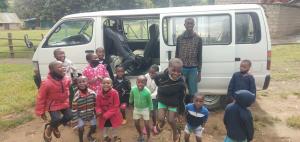 The newly-repaired minibus along with several of the many children, overjoyed to have their primary means of transport back